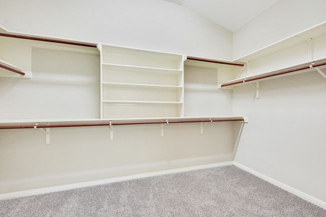 The spacious primary suite is a true retreat, complete with a luxurious bath featuring dual vanities, a walk-in shower, a soaking tub, and an oversized walk-in closet. | Image 27