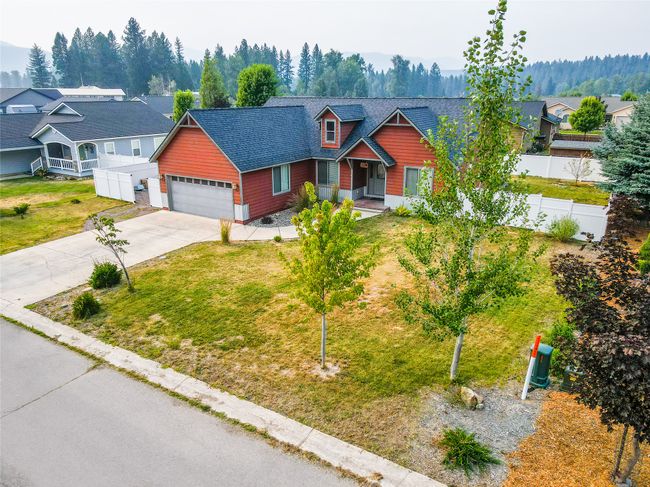 View of front of house with roof with shingles, driveway, a front yard, a garage, and fence | Image 9