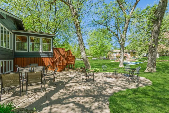 Endless possibilities with this beautiful stamped concrete patio! Enjoy time around your built in bonfire pit and still have tons of space for guest to gather for a picnic and to enjoy the shade. | Image 53