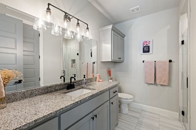 Bathroom with toilet, a stall shower, baseboards, visible vents, and vanity | Image 21