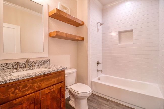 Full bathroom with toilet, wood-type flooring, tub / shower combination, ornamental molding, and vanity | Image 17