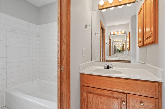 The main bathroom on the upper level offers 2 single vanities, a bathtub/shower combo, and a convenient pocket door separating the vanities from the toilet and shower space. | Image 27