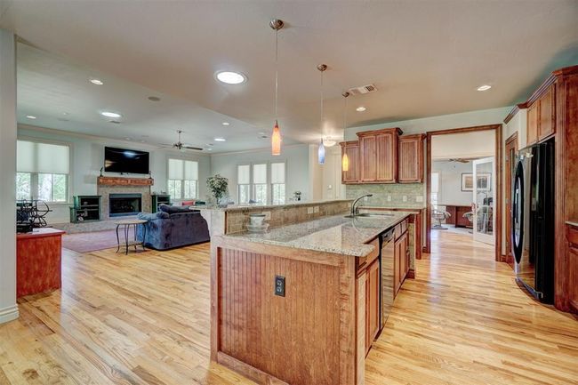 Kitchen with freestanding refrigerator, light wood finished floors, and a sink | Image 14