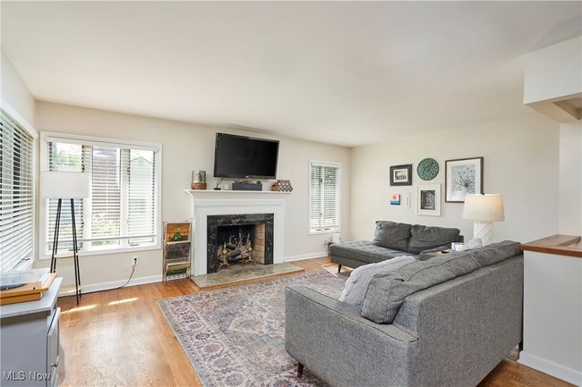 Living area with a high end fireplace, plenty of natural light, light wood-style flooring, and baseboards | Image 8