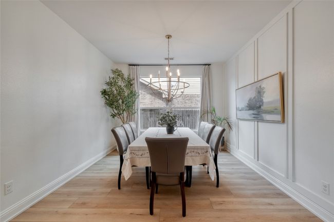 Dining space featuring a chandelier and light wood finished floors | Image 6