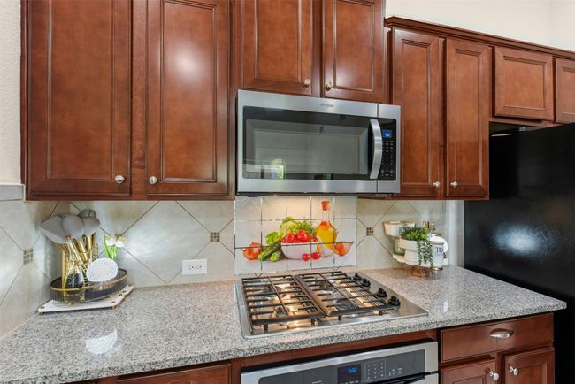 Gas cooktop and built in. microwave and oven. Lots of cabinets for storage and counter space for meal prep. | Image 6