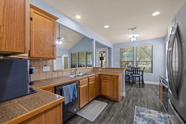Kitchen with tasteful backsplash, Granite tile counters, and stainless steel appliances | Image 15