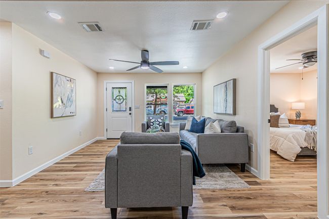 Living room featuring a ceiling fan, visible vents, and light wood-type flooring | Image 6