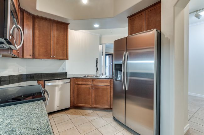 Step into the chef-ready galley kitchen, where premium stainless-steel appliances and a deep undermount sink are flanked by walls of elegant shaker-style cabinetry, plus a spacious pantry to keep every utensil and ingredient perfectly organized. | Image 21