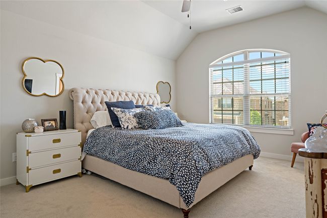 Bedroom featuring light colored carpet, ceiling fan, and lofted ceiling | Image 11