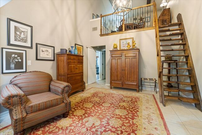 Sitting room featuring a towering ceiling, a chandelier, light tile patterned flooring, stairs, and visible vents | Image 26