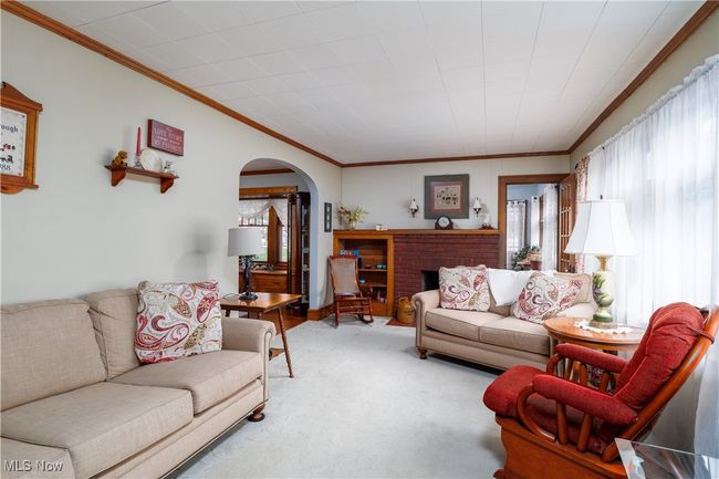 Living room featuring arched walkways, crown molding, and light carpet | Image 7