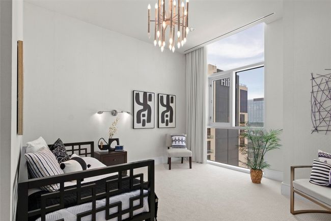 one of the secondary bedrooms with ample nature light streaming through expansive glass windows | Image 23