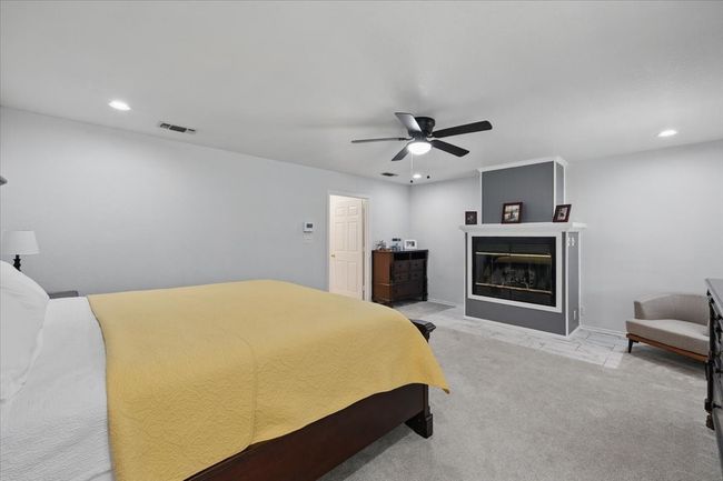 Bedroom featuring recessed lighting, ceiling fan, and a glass covered fireplace | Image 16