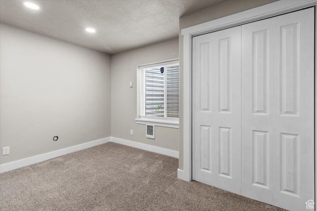 Unfurnished bedroom with carpet, baseboards, recessed lighting, a textured ceiling, and a closet | Image 35