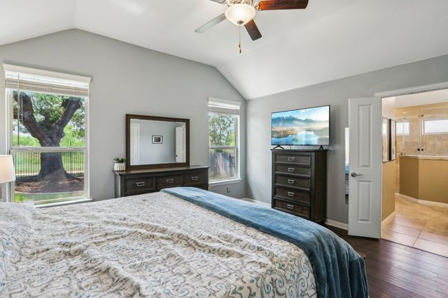 Bedroom featuring wood-type flooring, lofted ceiling, multiple windows | Image 16