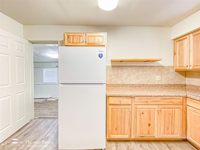 Kitchen featuring freestanding refrigerator, light brown cabinets, light wood-style floors, and light countertops | Image 16