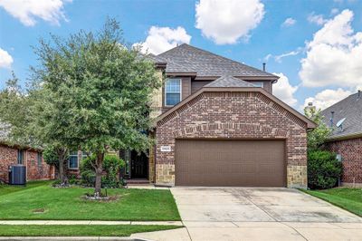 Front facade with cooling unit, a garage, and a front lawn | Image 1