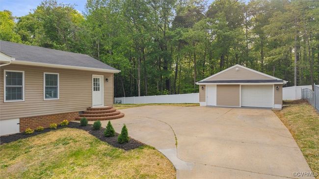 View of yard featuring an outbuilding, a detached garage, and fence | Image 42