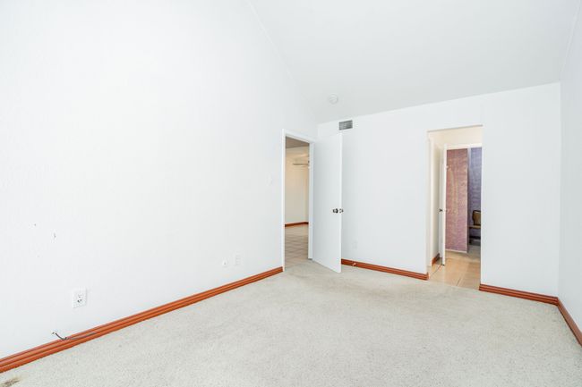 Spare room featuring light colored carpet, baseboards, visible vents, and high vaulted ceiling | Image 10
