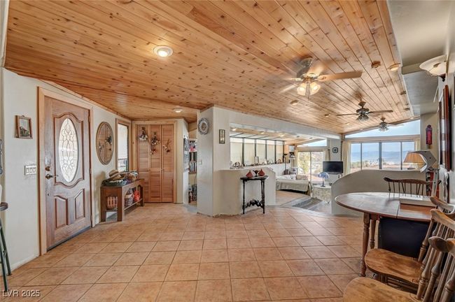 Foyer featuring wood ceiling, ceiling fan, light tile patterned floors, and lofted ceiling | Image 24