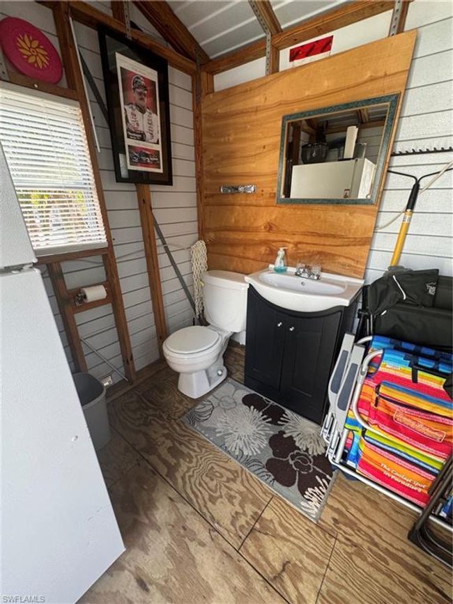 Bathroom with vanity, wooden walls, and toilet | Image 29