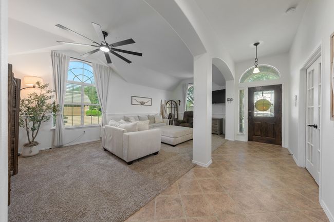 Foyer entrance featuring healthy amount of natural light, arched walkways, a ceiling fan, baseboards, and lofted ceiling | Image 4