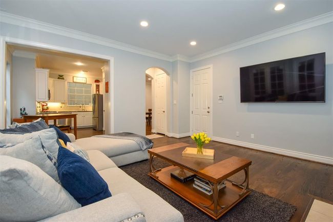 Living room with a view into the kitchen area. | Image 15