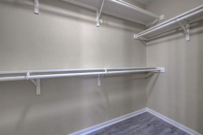 Spacious closet with dark wood-type flooring | Image 17