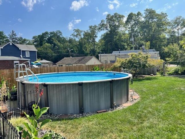View of pool with a yard, a fenced in pool and a fenced backyard | Image 29