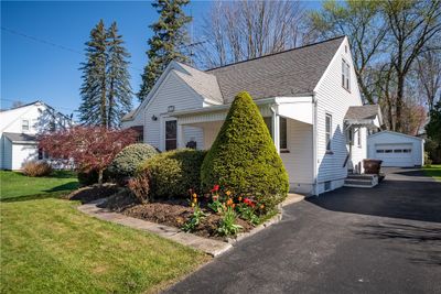 Covered front porch hidden from the road by shrubs offers a private spot to relax! | Image 2