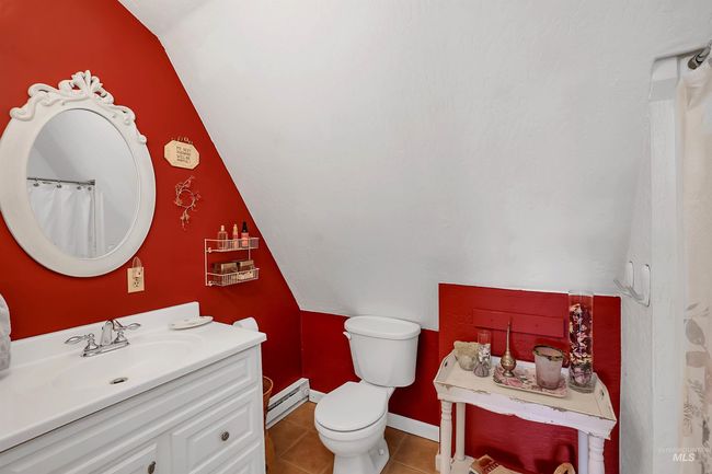 Full bath with lofted ceiling, vanity, tile patterned floors, and a baseboard heating unit | Image 34