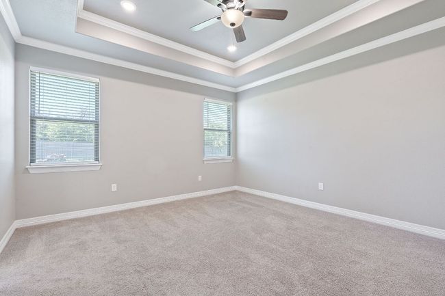 Carpeted spare room with ornamental molding, a raised ceiling, ceiling fan, and recessed lighting | Image 18