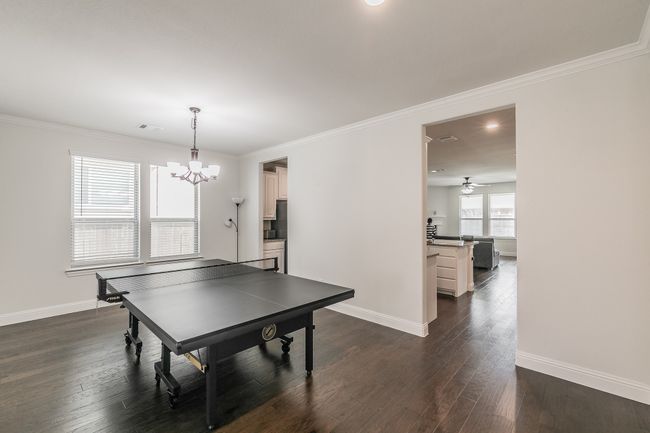 Playroom with visible vents, baseboards, dark wood-type flooring, and crown molding | Image 38