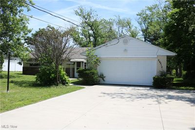 Ranch-style home with a front yard and a garage | Image 1