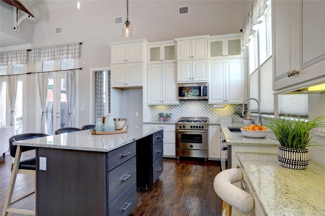 Kitchen featuring tall white cabinetry, stainless steel appliances and dual sink. | Image 5