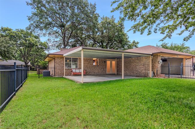 Rear view of house with a patio area, french doors, brick siding, and central AC unit | Image 25