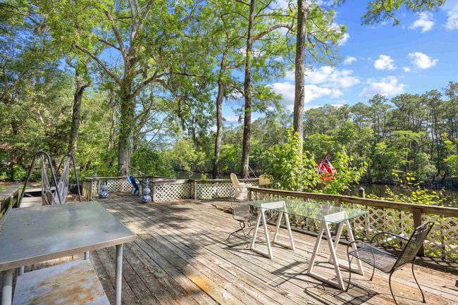 Wooden deck with outdoor dining space and view of scattered trees | Image 35