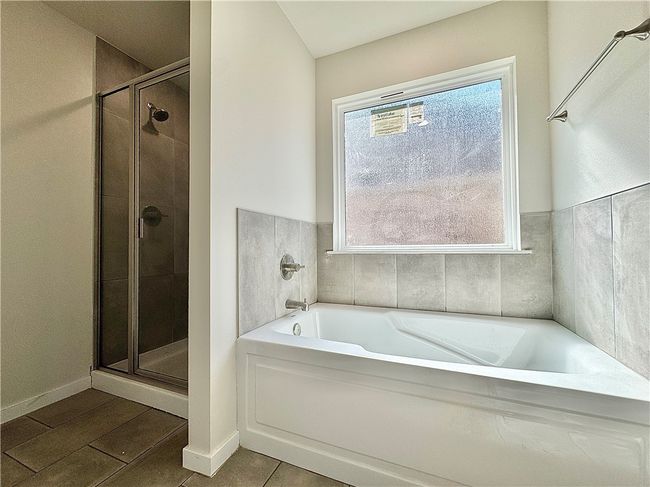 Pamper yourself in the lavish master bathroom, featuring a generously sized walk-in shower that envelops you in a cascade of soothing water or relax in the tub, while the double sinks provide ample space for personal care routines and a touch of modern elegance. | Image 12
