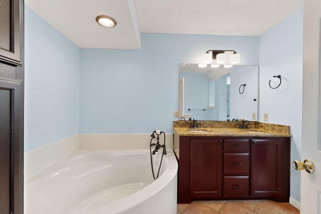 Full bath featuring tile patterned floors, a garden tub, and double vanity | Image 14