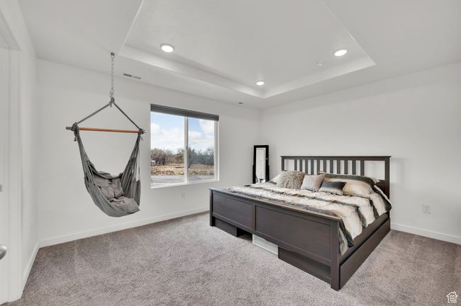 Bedroom featuring baseboards, carpet floors, a tray ceiling, and visible vents | Image 13