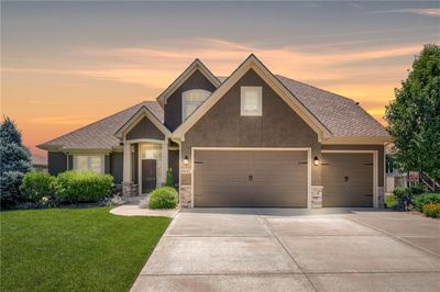 Craftsman-style house featuring a garage and a yard | Image 1