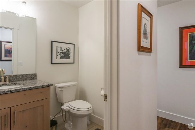 Half bathroom with toilet, vanity, wood finished floors, and baseboards | Image 24