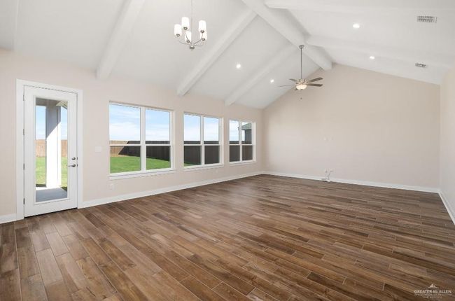 Unfurnished living room with visible vents, baseboards, lofted ceiling with beams, dark wood finished floors, and recessed lighting | Image 5