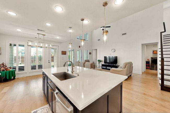 Kitchen featuring a sink, dishwasher, light wood finished floors, light countertops, and recessed lighting | Image 13