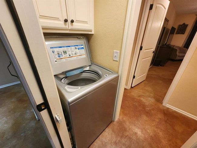 Washroom with washer / clothes dryer, cabinet space, and a textured wall | Image 19