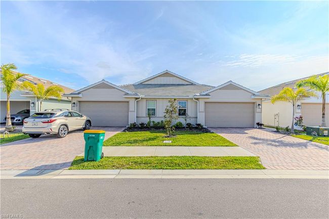 Single story home with decorative driveway, a tiled roof, and an attached garage | Image 22