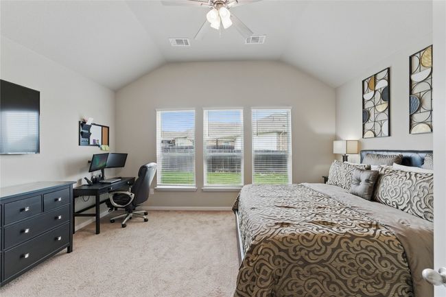 Bedroom with visible vents, baseboards, light carpet, and lofted ceiling | Image 19