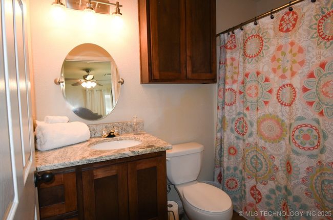 Full bath featuring vanity, toilet, a ceiling fan, and a shower with curtain | Image 23