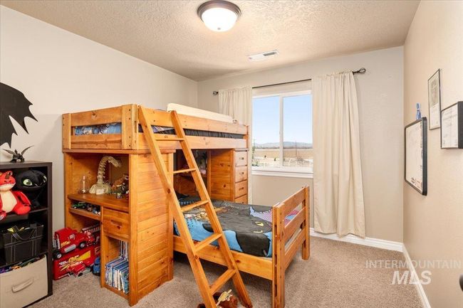 Carpeted bedroom with a textured ceiling and baseboards | Image 19